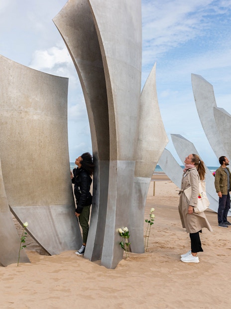 Tour group exploring Les Braves Memorial on Omaha Beach, Normandy.
