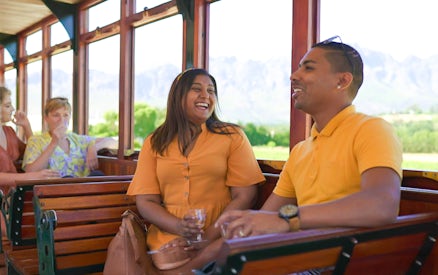 Couple enjoying Franschhoek Wine Tram Xplorer Tour, Cape Town.