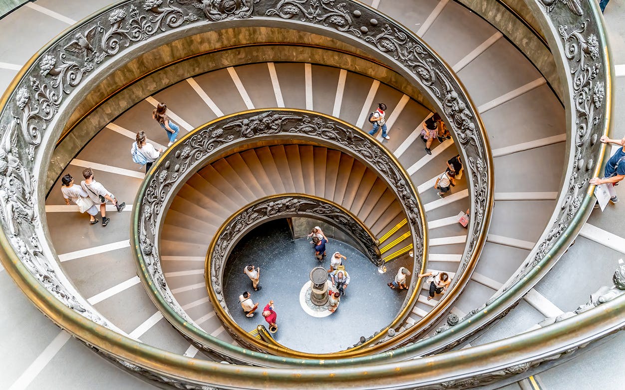 Visitors descending spiral staircase in Vatican City.