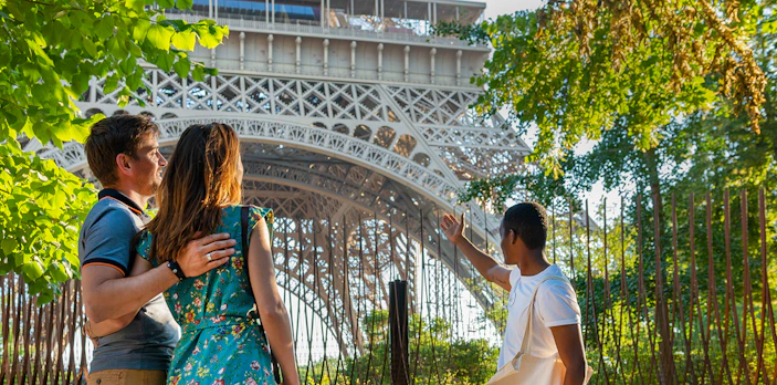 Tour guide showing visitors the Eiffel Tower's 2nd floor during Paris city tour.