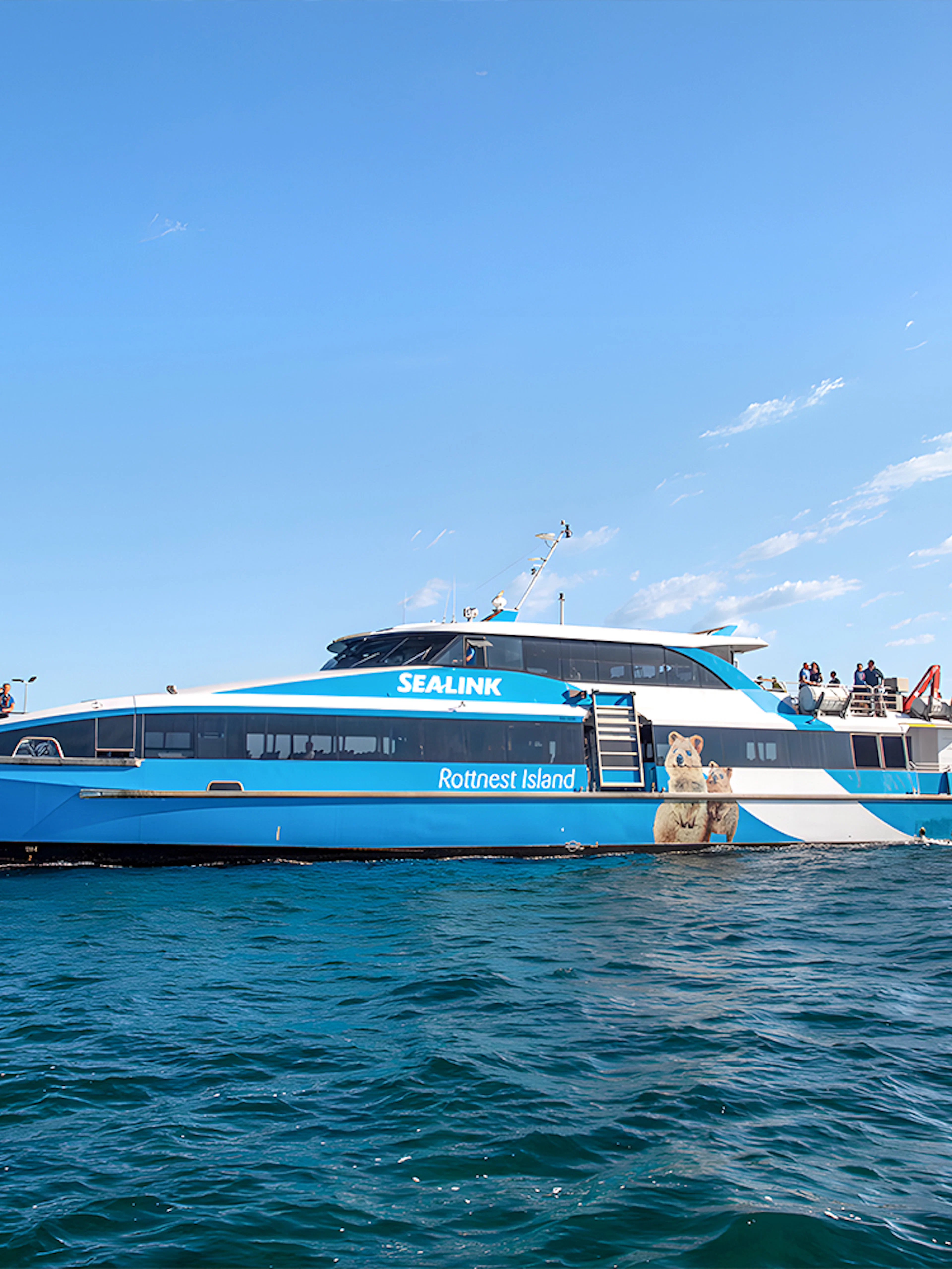 Ferry to Rottnest Island with tourists on deck, coastline visible in background.
