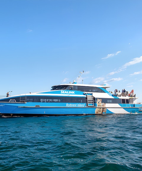 Ferry to Rottnest Island with tourists on deck, coastline visible in background.