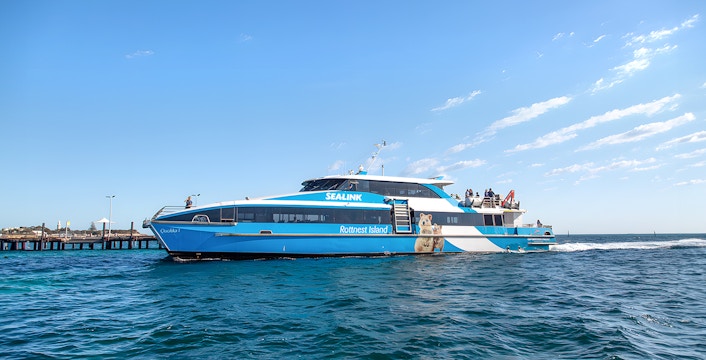 Ferry to Rottnest Island with tourists on deck, coastline visible in background.