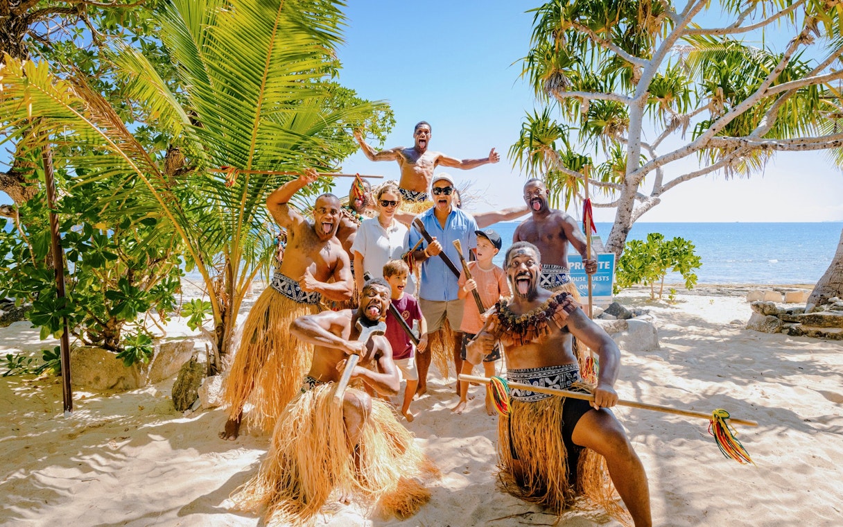 Group enjoying traditional dance on South Sea Island beach, Fiji.
