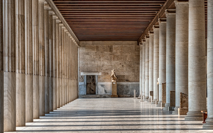 Stoa of Attalos interior with marble columns and statue in Athens, Greece.