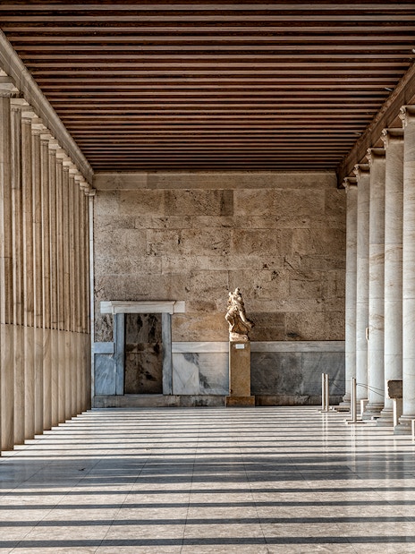 Stoa of Attalos interior with marble columns and statue in Athens, Greece.