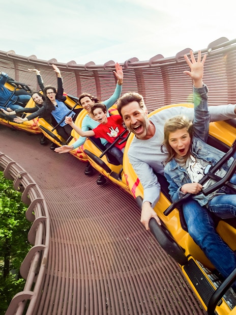 Roller coaster riders enjoying a thrilling descent at Astérix Park in Paris, France.