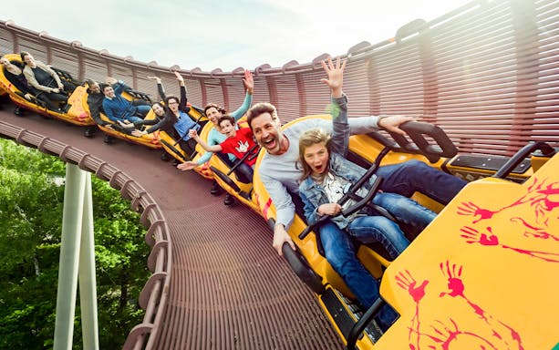 Roller coaster riders enjoying a thrilling descent at Astérix Park in Paris, France.