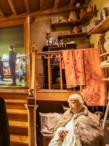 Visitors viewing a historical exhibit at Historium Bruges, featuring a medieval scene projection.