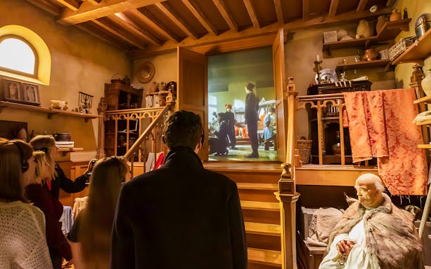 Visitors viewing a historical exhibit at Historium Bruges, featuring a medieval scene projection.