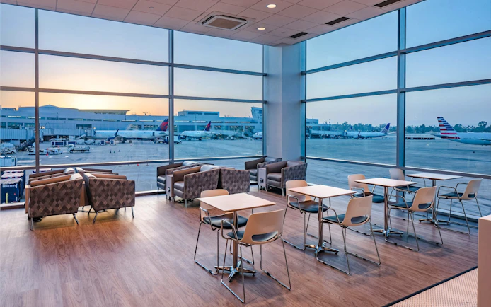 Aspire Lounge seating area overlooking runway at San Diego International Airport.