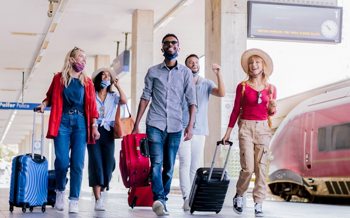 Travelers with luggage at Munich train station for Neuschwanstein Castle tour.