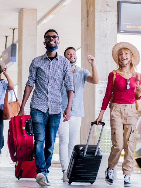 Travelers with luggage at Munich train station for Neuschwanstein Castle tour.