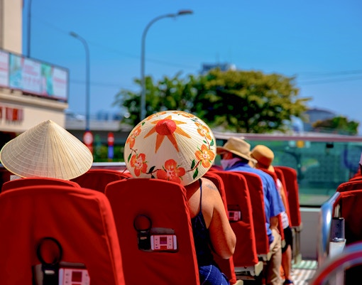 Passengers on the upper deck of Valencia Hop on Hop Off Bus with city view.