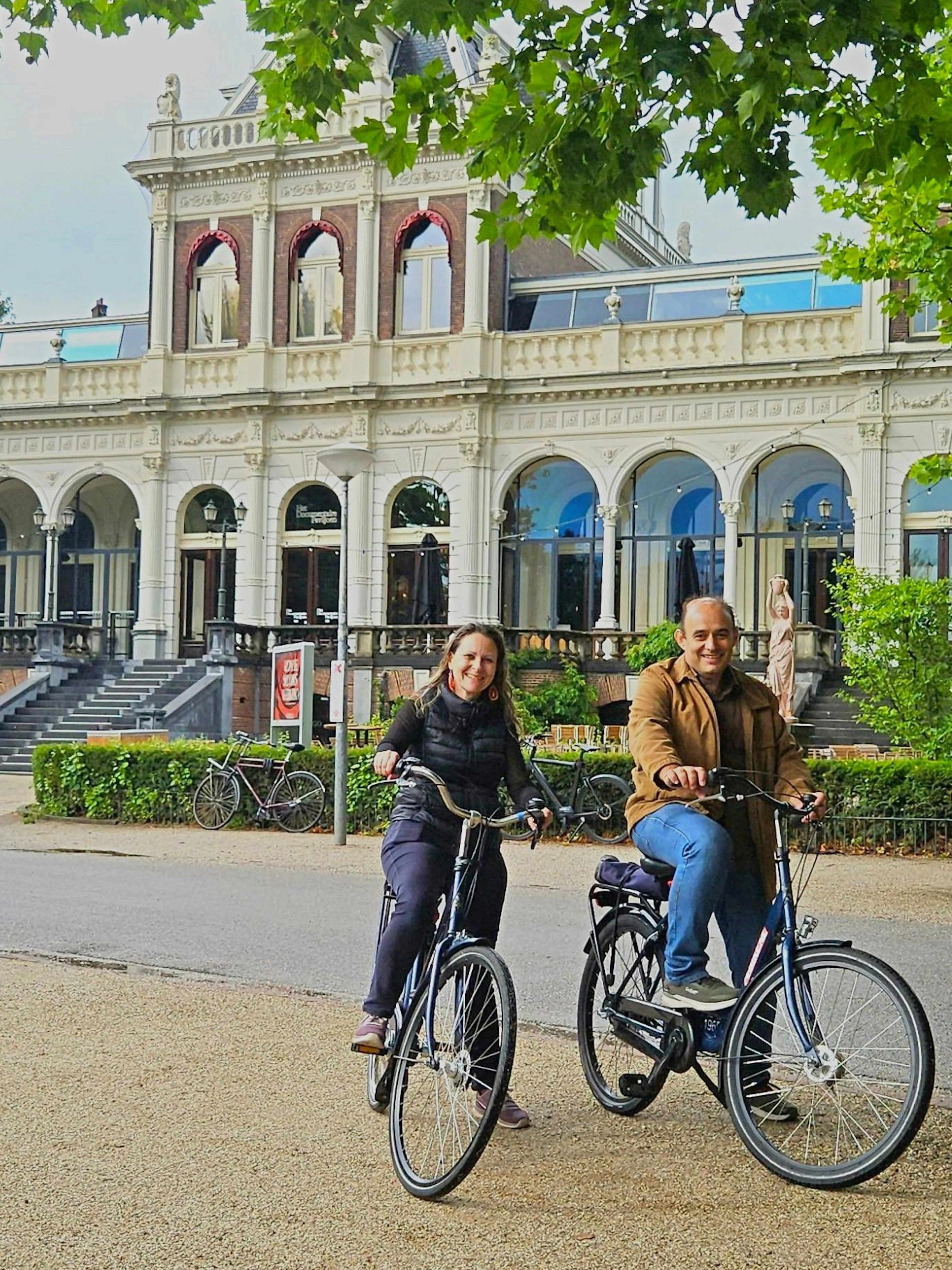 Cyclists enjoying a city highlights bike tour near a historic building.