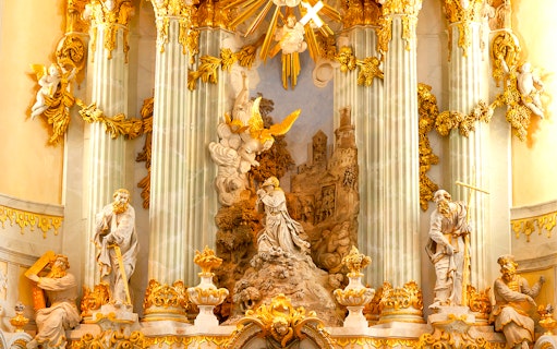 Frauenkirche interior with ornate sculptures and golden decorations on a guided gallery tour.