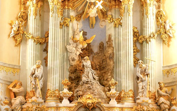 Frauenkirche interior with ornate sculptures and golden decorations on a guided gallery tour.