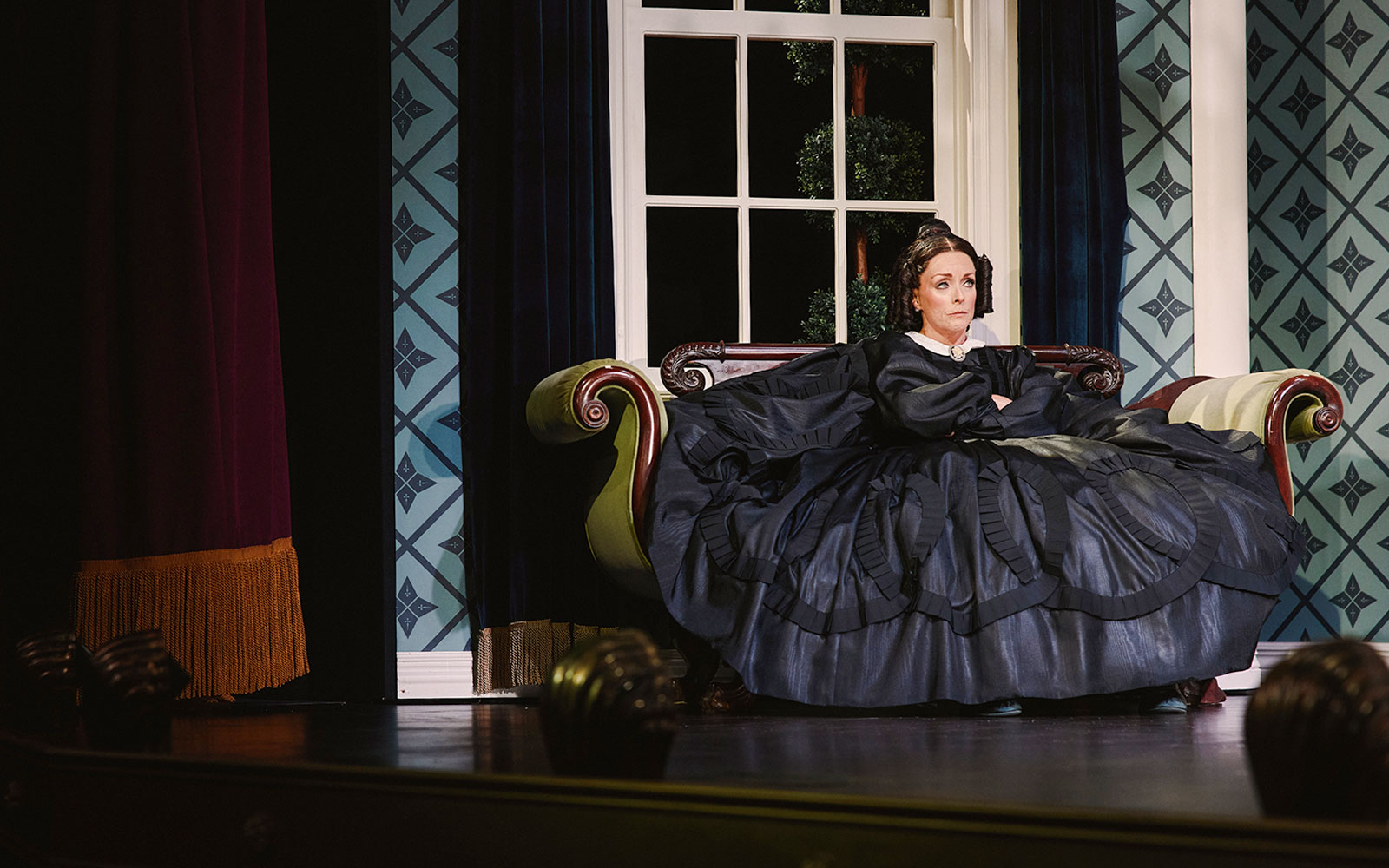 Stage scene from Oh, Mary! Broadway show with actor in period costume on a vintage sofa.