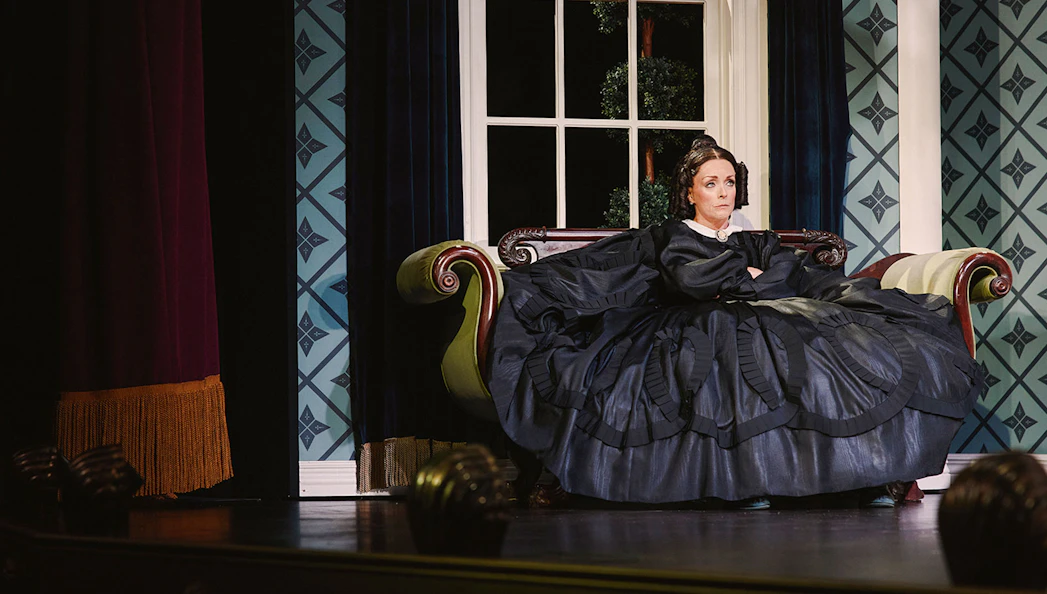 Stage scene from Oh, Mary! Broadway show with actor in period costume on a vintage sofa.