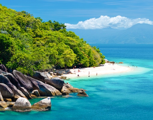 Fitzroy Island beach with clear water and lush greenery, Cairns day trip.