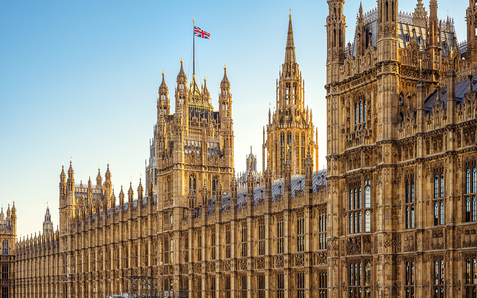 Facade of the Palace of Westminster with Union Jack flag, London.