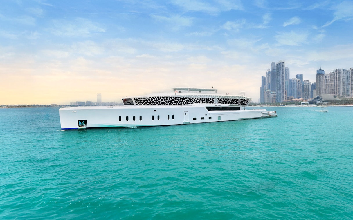 Lotus Mega Yacht cruising near Dubai Marina with city skyline in the background.