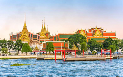 Grand Palace view from Chao Phraya River, Bangkok, with hop-on-hop-off boat dock.