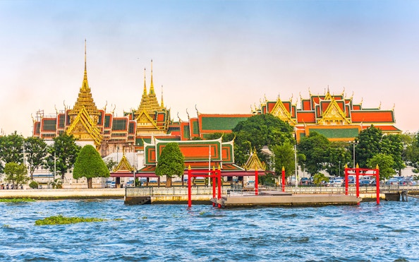 Grand Palace view from Chao Phraya River, Bangkok, with hop-on-hop-off boat dock.