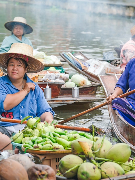 Vendors selling fruits and vegetables on boats at Damnoen Saduak Floating Market, Bangkok.