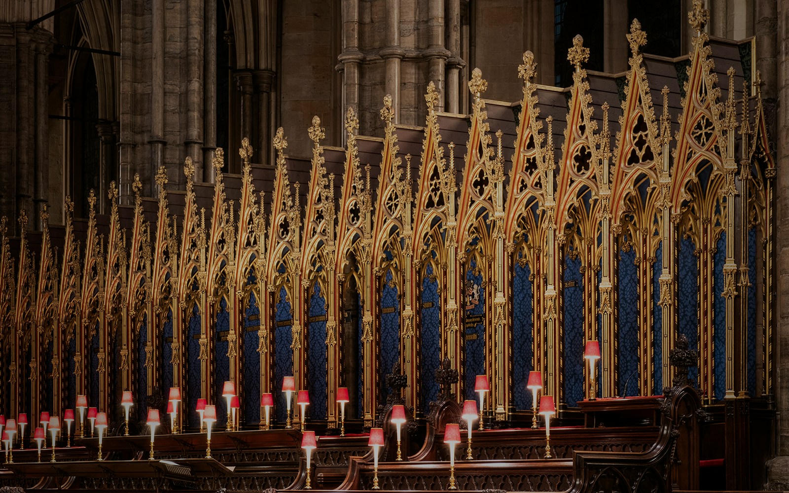Ornate choir stalls with golden detailing at Westminster Abbey, London.