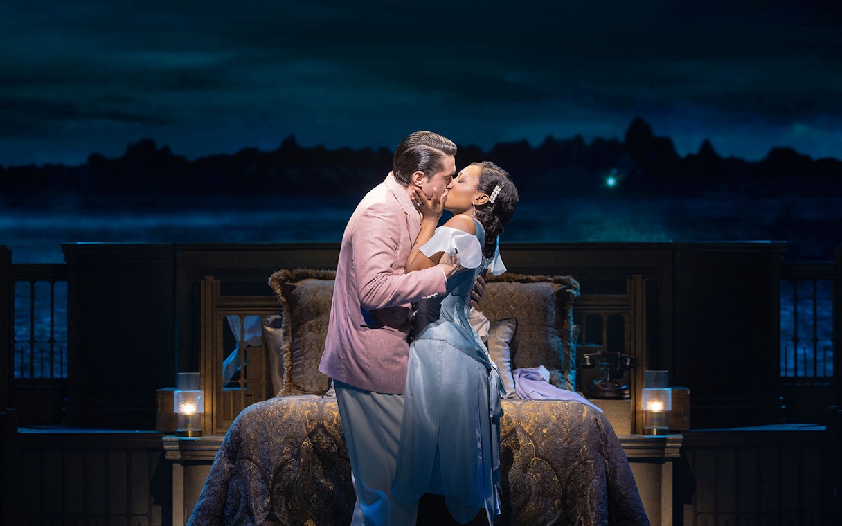 Couple embracing on stage in a scene from The Great Gatsby musical.