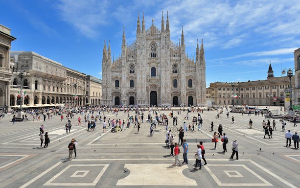 Piazza del Duomo with Milan Cathedral, bustling with tourists on an open bus tour.
