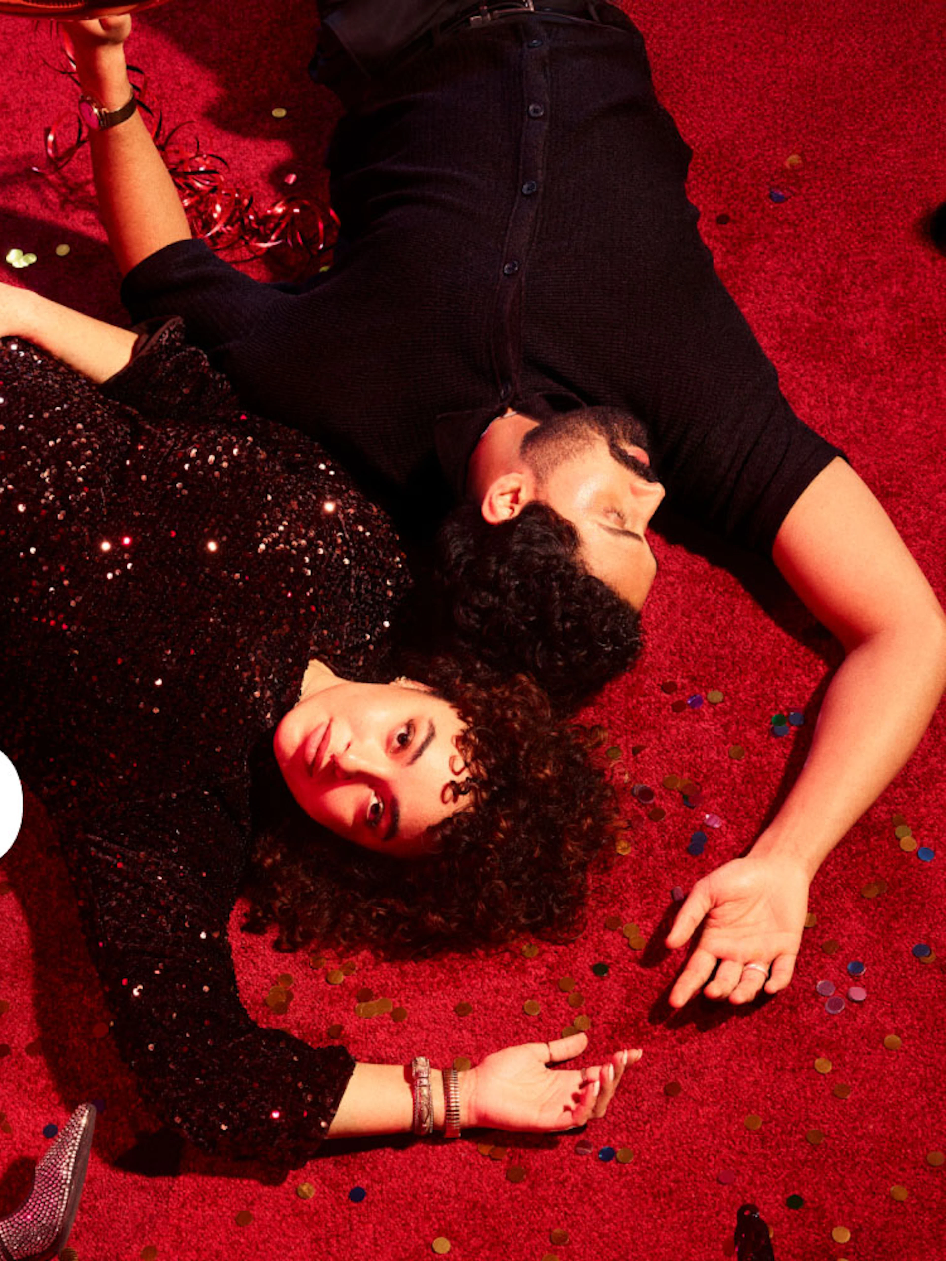 Couple lying on red carpet with confetti, promoting Much Ado About Nothing Westend.