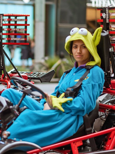 Couple in costumes driving go-karts on Asakusa tour, Tokyo.