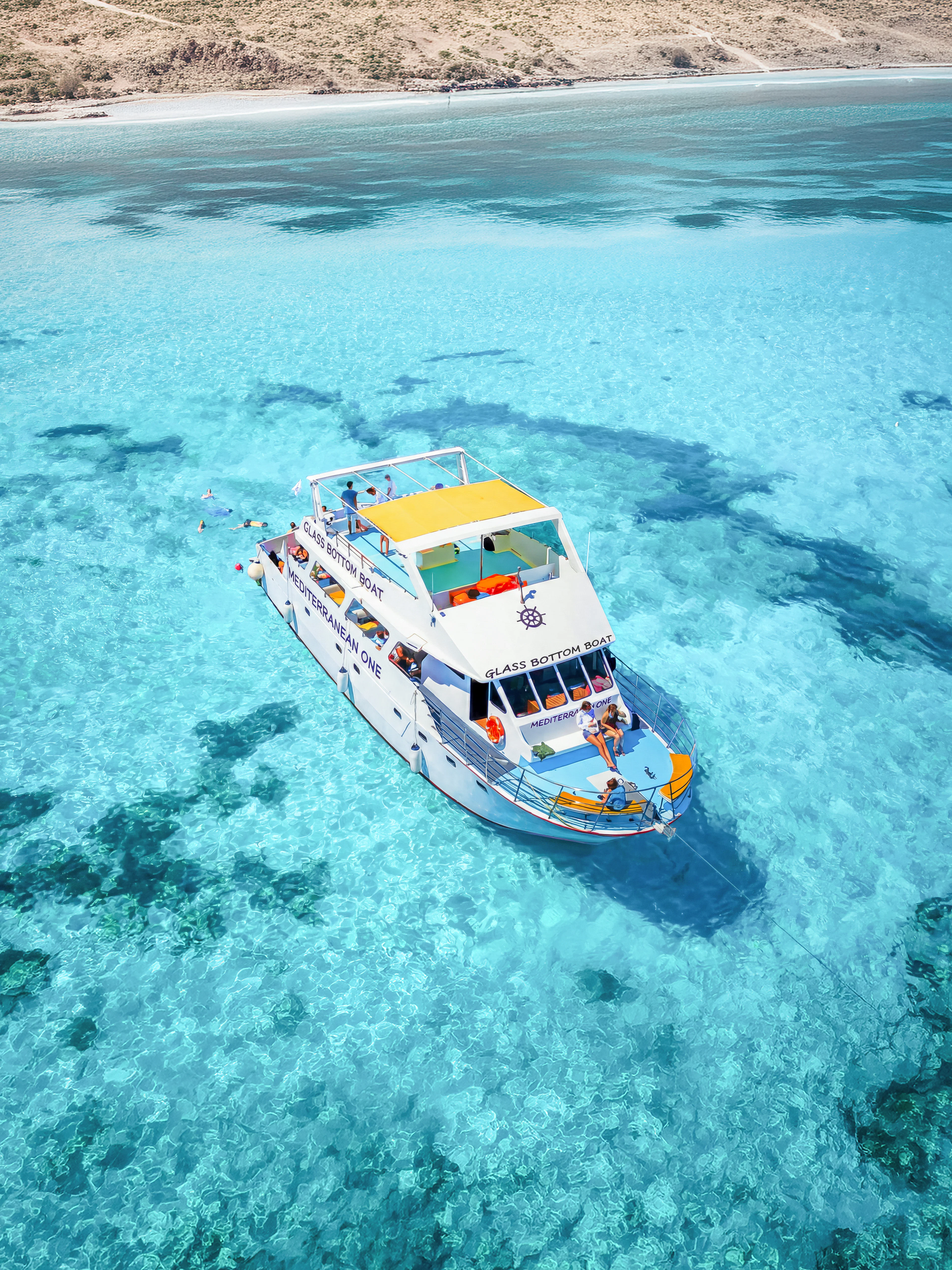 Boat on clear blue waters of Blue Lagoon, Paphos, Cyprus.