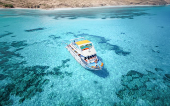Boat on clear blue waters of Blue Lagoon, Paphos, Cyprus.