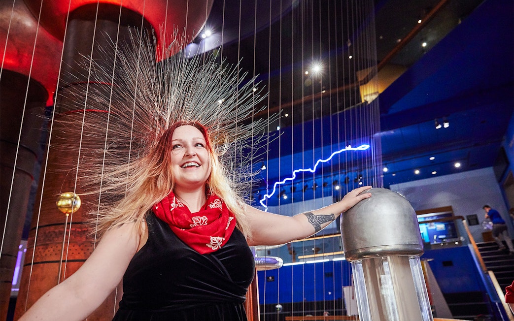 Woman experiencing static electricity at Museum of Science Theater of Electricity, Boston.