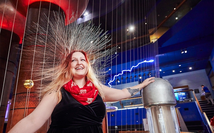Woman experiencing static electricity at Museum of Science Theater of Electricity, Boston.