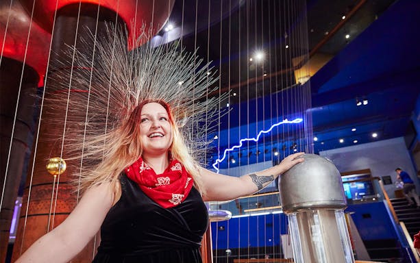 Woman experiencing static electricity at Museum of Science Theater of Electricity, Boston.