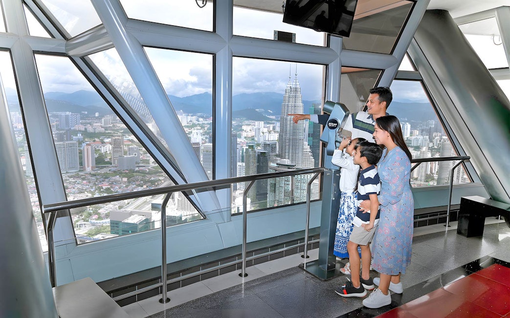 Family enjoying city view from KL Tower Sky Deck, Kuala Lumpur.