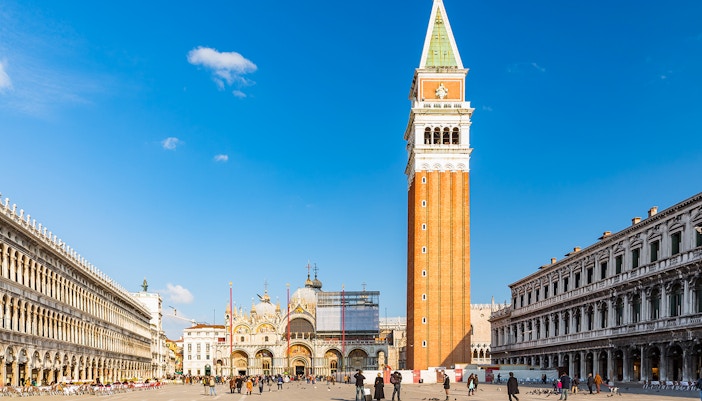 Tour guide leading a group at St. Mark's Basilica with a gondola ride in Venice, Italy