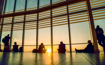 Sunset view from Sky Costanera, Chile, with people silhouetted against large windows.