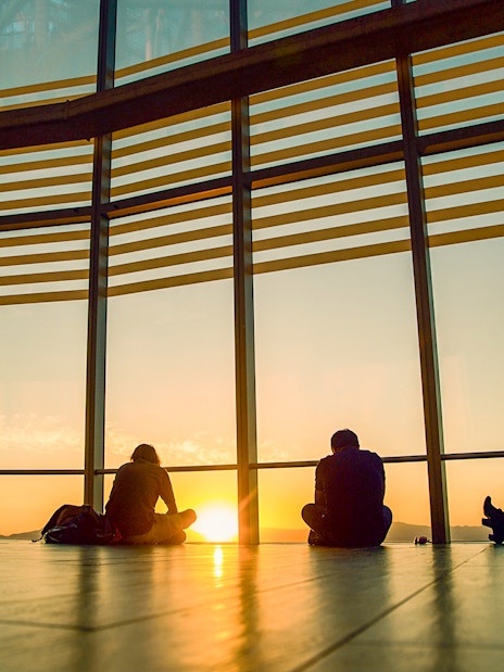 Sunset view from Sky Costanera, Chile, with people silhouetted against large windows.