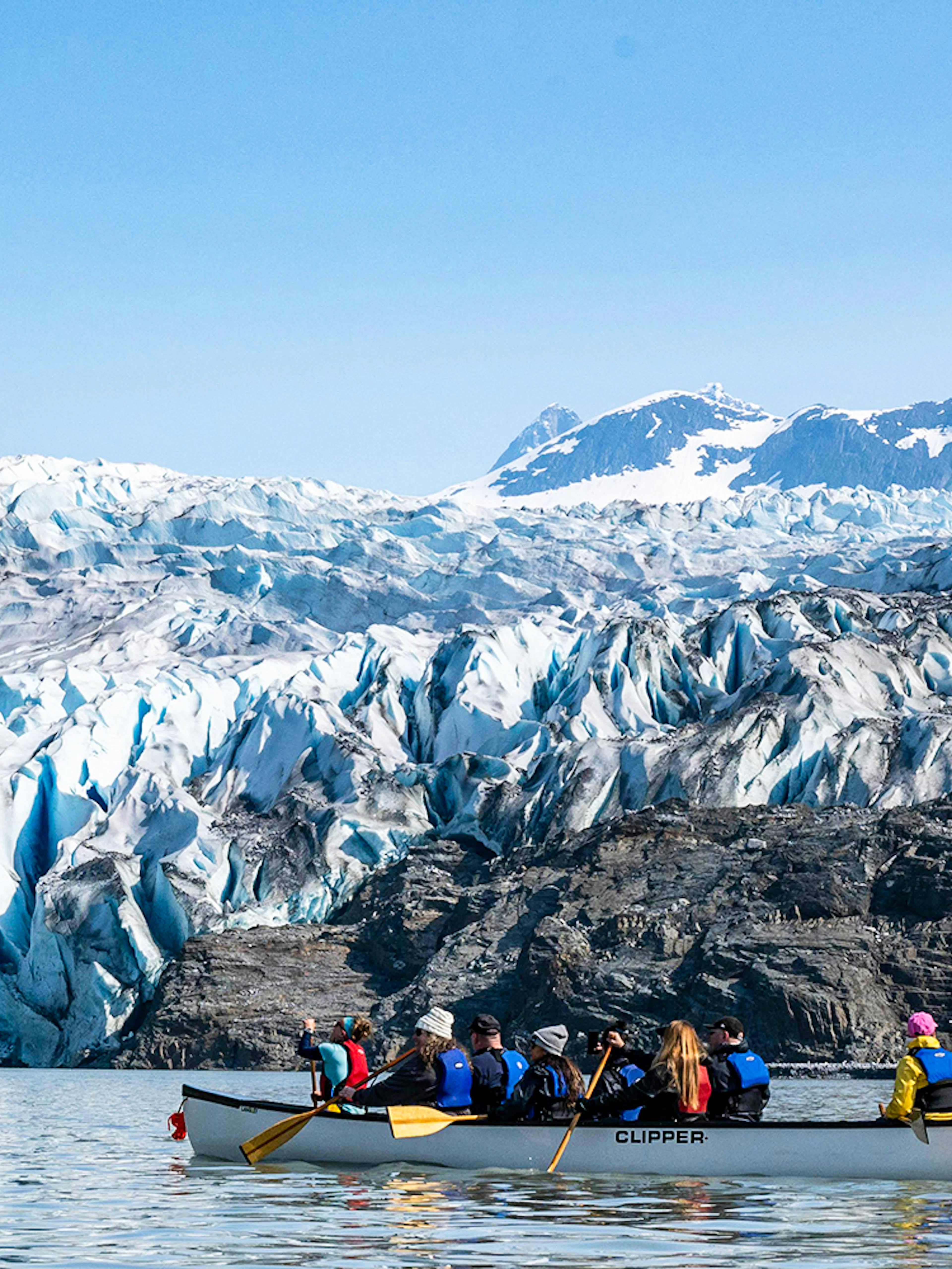Canoe group paddling near Mendenhall Glacier in Alaska.