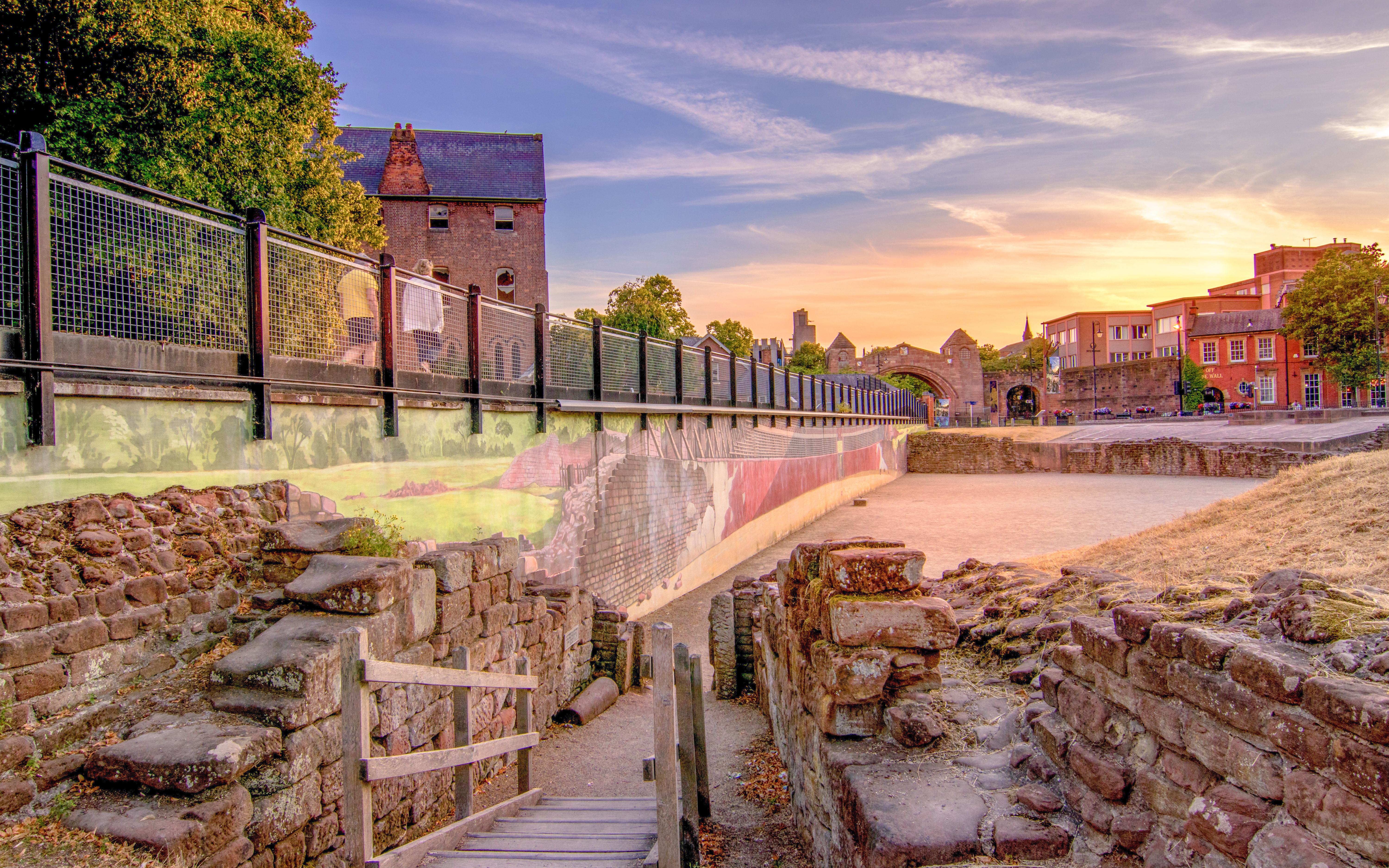 Sunset view of the Roman Amphitheatre in Chester, England with ancient stone walls.