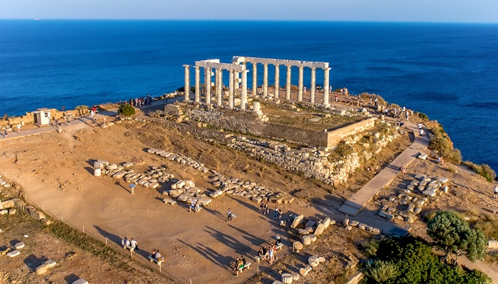 Aerial view of the ancient Temple of Poseidon at Cape Sounio, Attica, Greece during sunset.