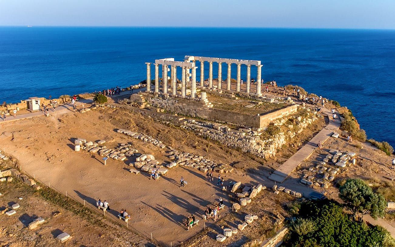 Aerial view of the Temple of Poseidon at Cape Sounio, Attica, Greece with surrounding sea.