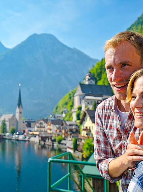 Couple enjoying the view of Hallstatt village and lake in Austria.