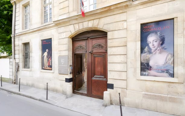 Exterior entrance of Cognacq-Jay Museum in Paris with art posters displayed.