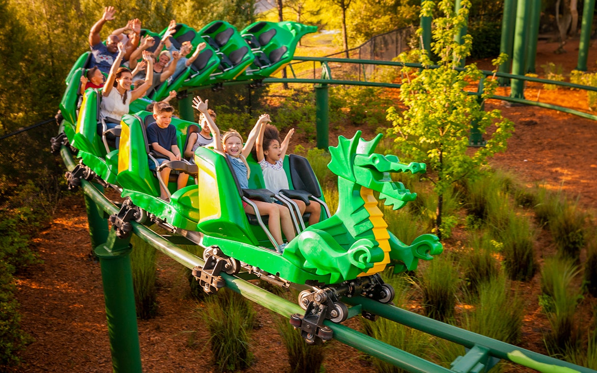 Visitors enjoying a dragon-themed roller coaster at LEGOLAND Windsor Resort.